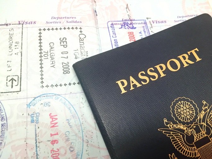 EU-Einreise-/Ausreisesystem: Schwarzer Reisepass und dahinter Reiseziele mit Flughafenstempel.
