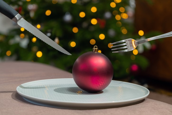 Restaurants für dein Weihnachtsessen in der Eifel.
Krimi Dinner:
Eine Weihnachtskugel liegt auf einem Teller auf dem Tisch. Verschwommenes Licht im Hintergrund, ein rotes Weihnachtsaccessoire auf dem Teller.